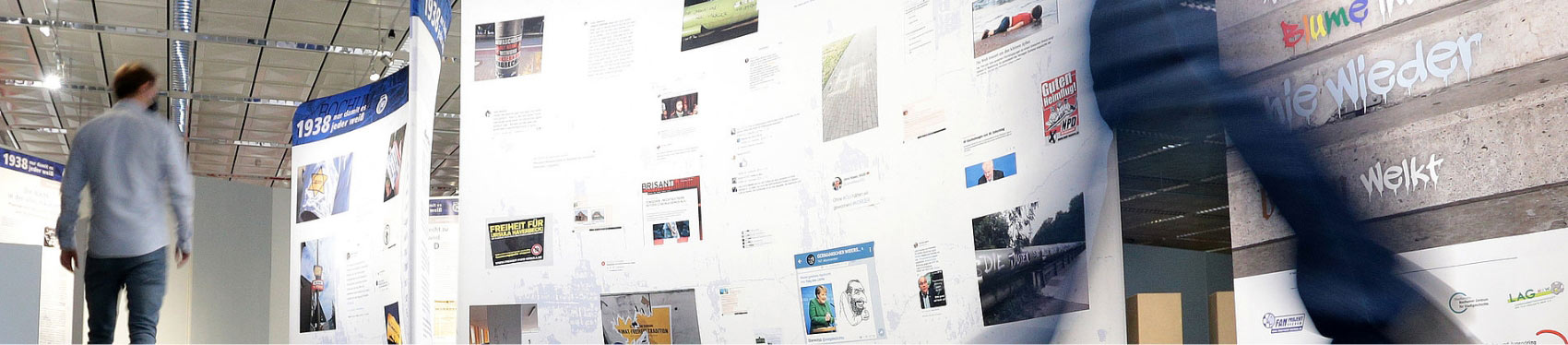 This is a banner of the exhibition website "our home our love" at the university library Bochum. You see two persons that walk across the roll-ups of the exhibition.